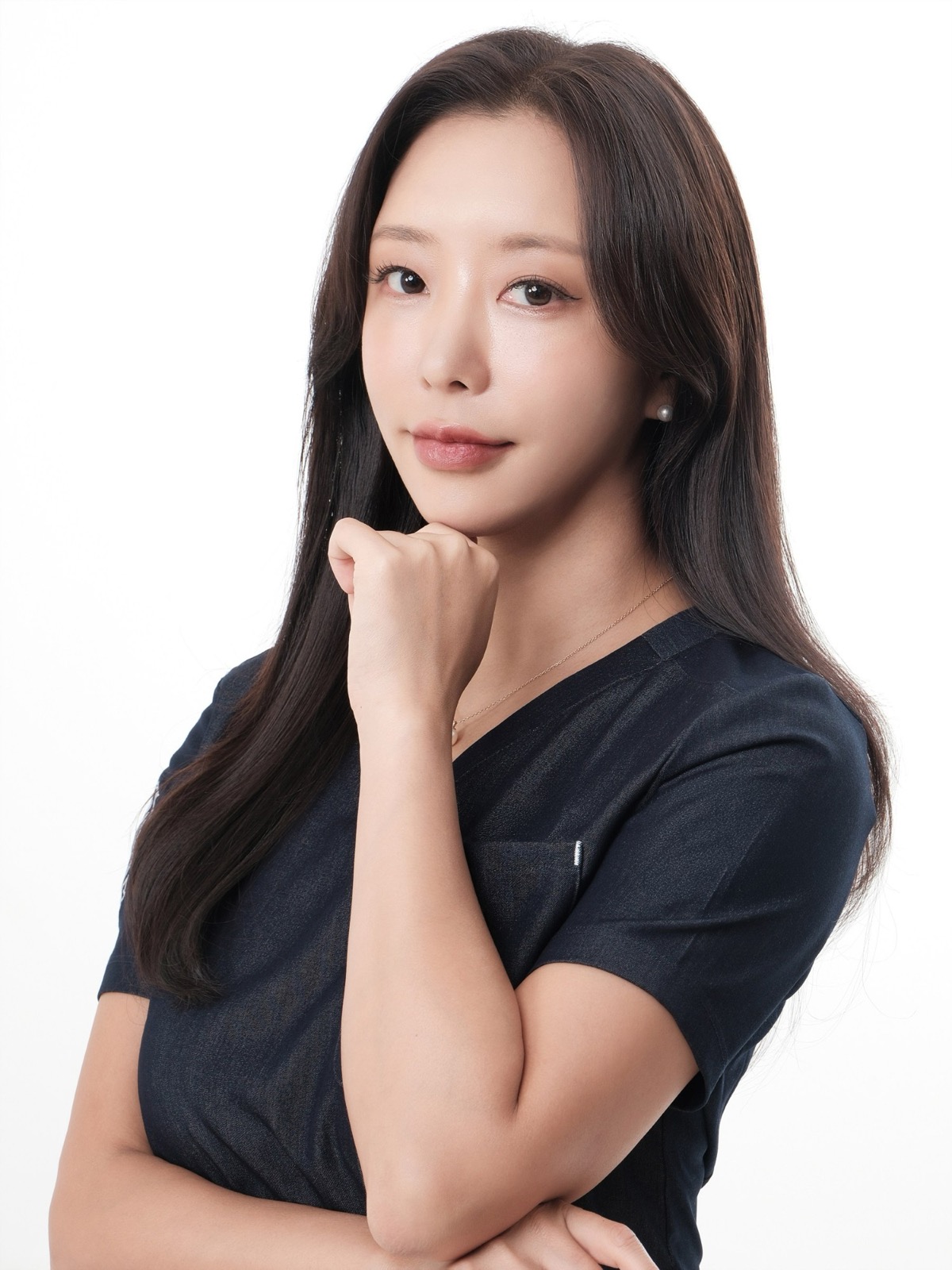 네이비 스크럽을 입고 턱을 괴 여성 원장 프로필, 흰 배경