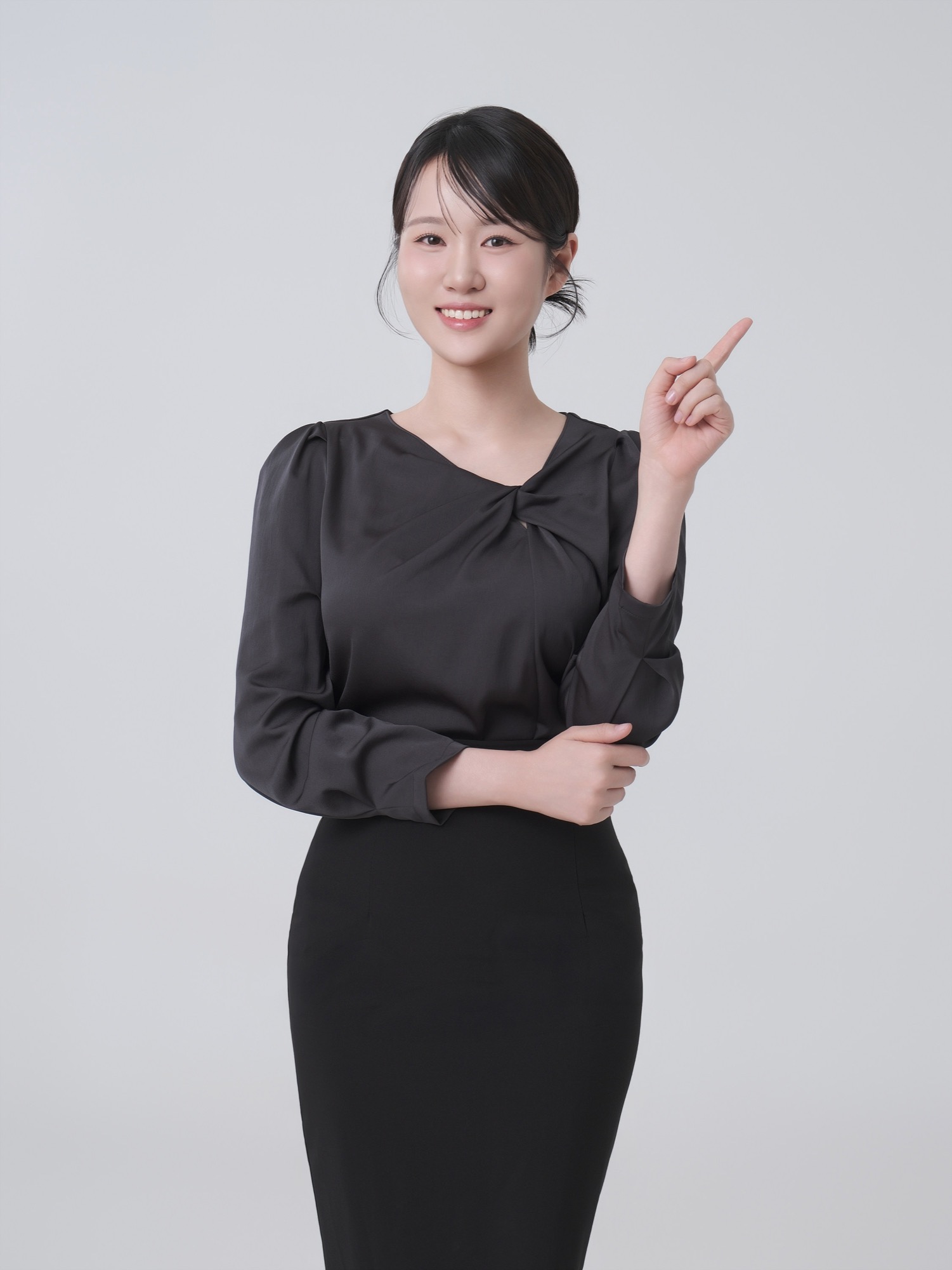 회색 배경에서 검은 블라우스를 입고 한 손으로 옆을 가리키며 웃는 여성 강사 프로필